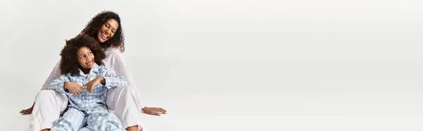 Black mother and daughter in PJs sitting together, banner — Stock Photo