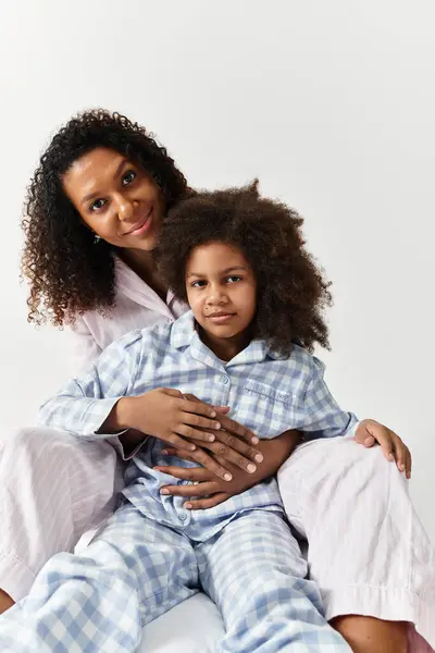 A beautiful African American mother cuddles her daughter. — Stock Photo