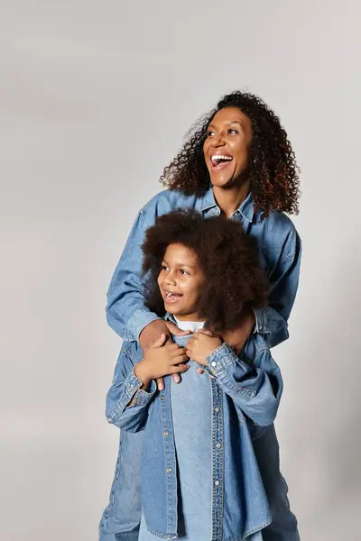 A joyful African American Mother embraces her smiling daughter. — Stock Photo