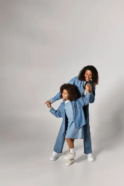 Maman et fille noires en denim, tenant la main. — Photo de stock