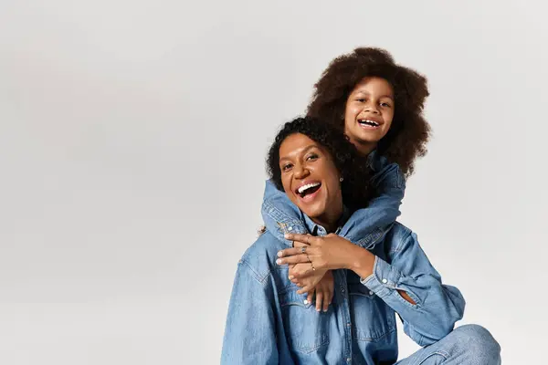 Schwarze Mutter und Tochter, passende Jeans, lachende Umarmung. — Stockfoto