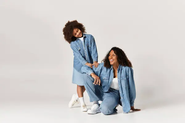 Black mother and daughter in denim clothes, tender moment. — Stock Photo