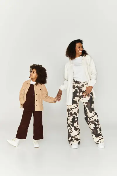 Mère et fille élégantes profiter de leur temps ensemble, mettant en valeur des tenues vibrantes et des sourires. — Photo de stock