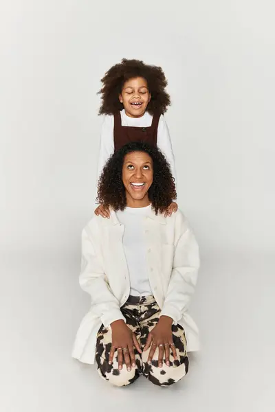 A happy mother and daughter embrace their bond in fashionable outfits featuring animal prints. — Stock Photo