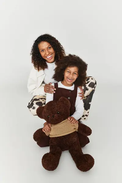 A mother and daughter duo showcase their stylish outfits while sharing a joyful moment together. — Stock Photo