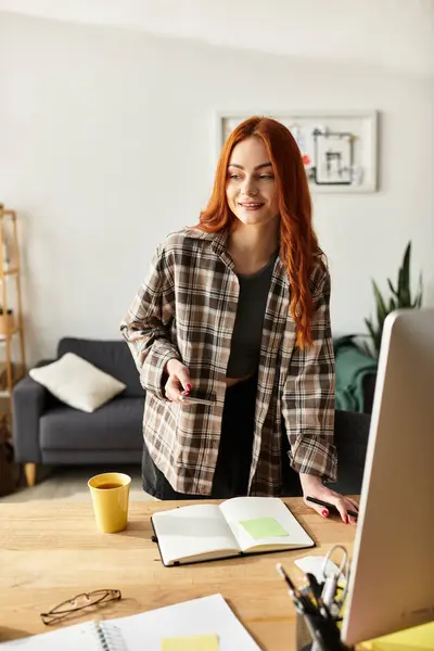 Una hermosa joven sonríe mientras organiza pensamientos en su cuaderno en una acogedora oficina en casa. — Stock Photo