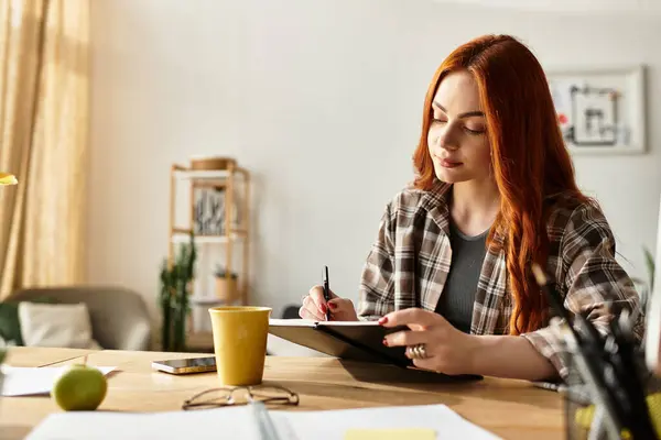 A young woman with red hair spends her spare time sketching in a sunlit room filled with plants. — Stock Photo