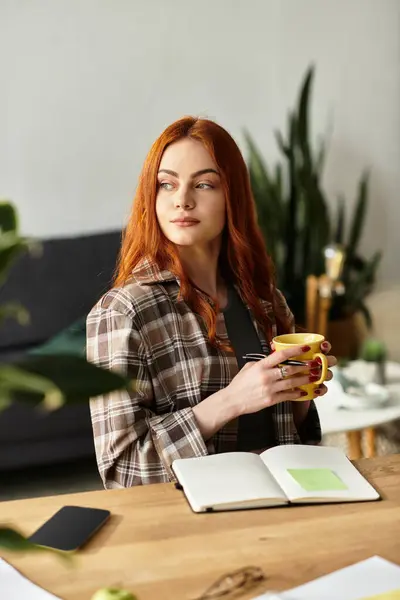 A young beautiful woman enjoys her spare time, sipping tea while brainstorming ideas at a desk. — Stock Photo