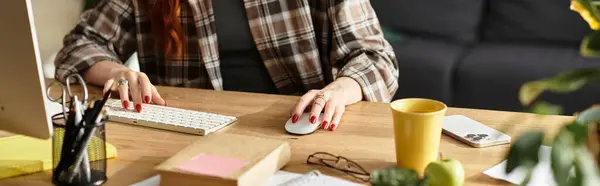 Расслабленная женщина сосредоточена на работе за своим аккуратным столом, окруженная растениями и личными вещами. — стоковое фото
