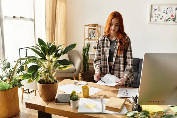 A young woman with vibrant hair explores her creativity in a comfortable, sunlit workspace. — Stock Photo