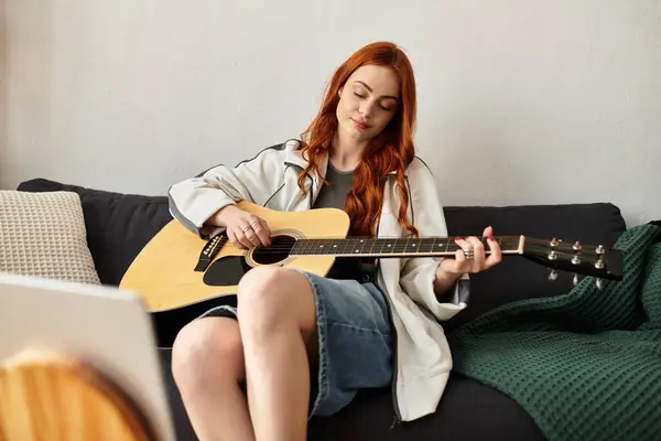A young woman plays guitar in her stylish living room during leisure time. — стоковое фото