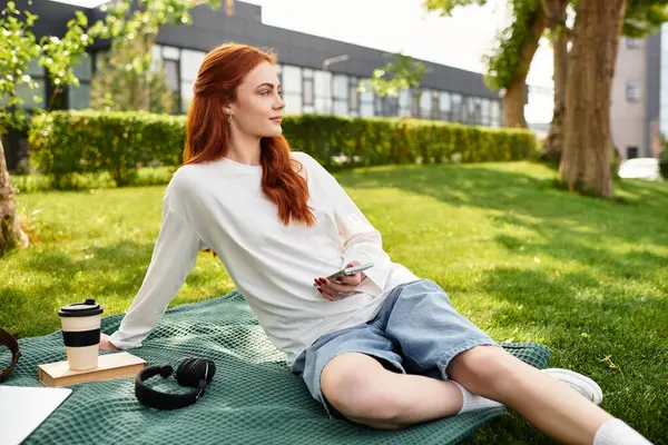 Young woman enjoys her spare time outdoors, lounging on a blanket in the grass. — Stock Photo