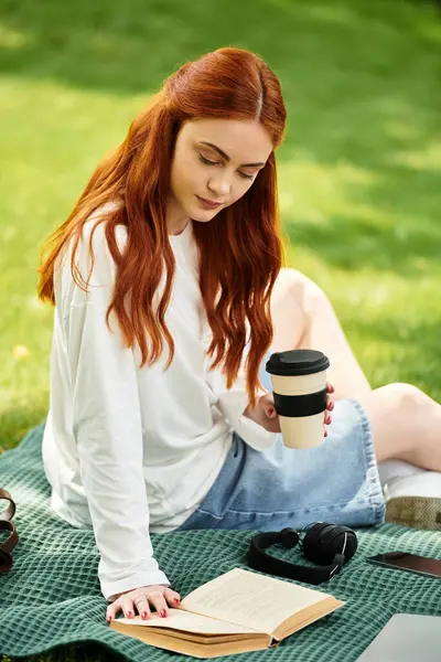 A young woman relaxes outdoors, sipping coffee while reading a book on a warm afternoon. — Stock Photo