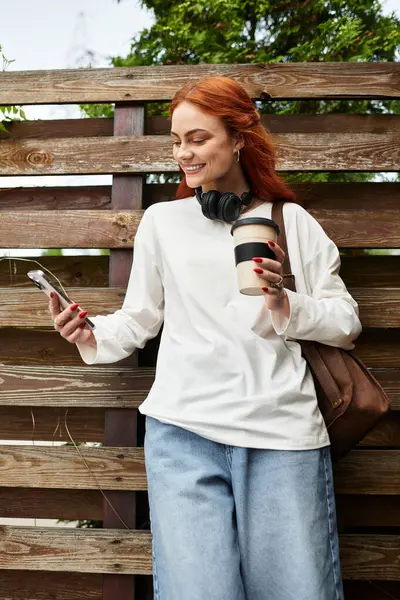 A young beautiful woman in casual attire enjoys her spare time with coffee outdoors. — Stock Photo