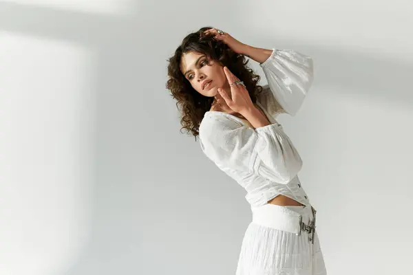 Une jeune belle femme pose gracieusement, mettant en valeur sa tenue tendance dans un espace moderne. — Photo de stock