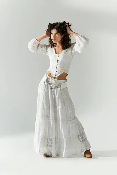 Fashion forward jeune femme pose en toute confiance dans un ensemble blanc élégant, soulignant l'élégance. — Photo de stock