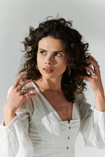 Beautiful woman with curly hair poses confidently, showcasing her stylish outfit and accessories. — Stock Photo