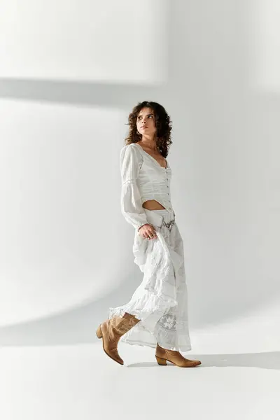 Una joven muestra su estilo en un vestido blanco impresionante, caminando con gracia. - foto de stock