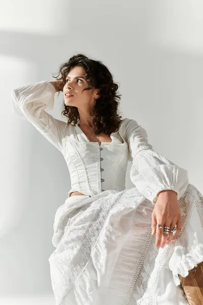 Bright light highlights a fashionable young woman posing gracefully in a stylish ensemble. — Stock Photo