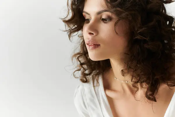 Charming young woman with beautiful curly hair poses gracefully, embodying modern fashion trends. — стоковое фото