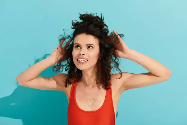 Jeune belle femme aux cheveux bouclés rayonne de confiance et de charme dans une tenue rouge audacieuse — Photo de stock