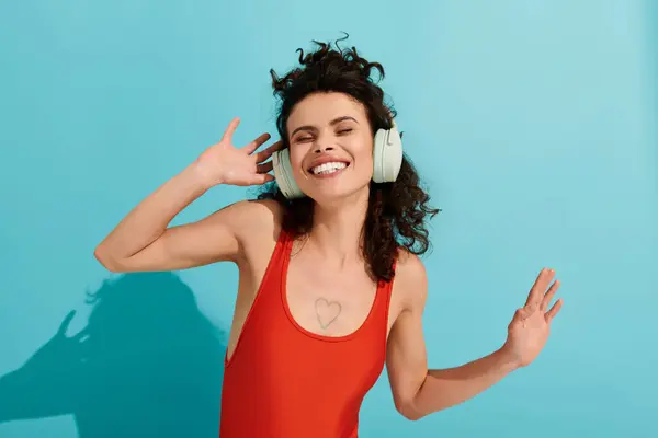 Una joven y hermosa mujer exuda felicidad mientras baila con auriculares en un entorno animado. - foto de stock