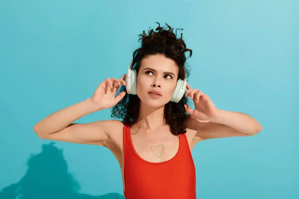 Beautiful young woman listens to music, expressing joy and style with colorful headphones. — стоковое фото