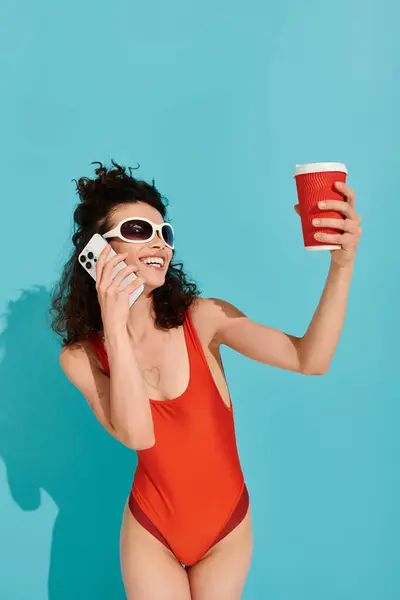 Eine fröhliche junge Frau in stylischer Badebekleidung genießt ihr Handy an einem warmen, hellen Tag. — Stockfoto
