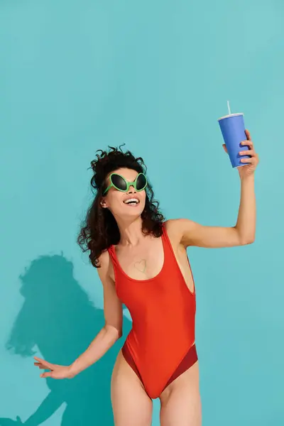 Leuchtende Farben werden lebendig, wenn eine schöne junge Frau vor Freude wirbelt und ihr Getränk in der Sonne schlürft.. — Stockfoto