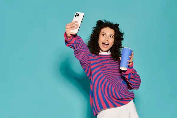 A young woman takes a selfie while holding a colorful drink, radiating fashion and happiness. — Stock Photo