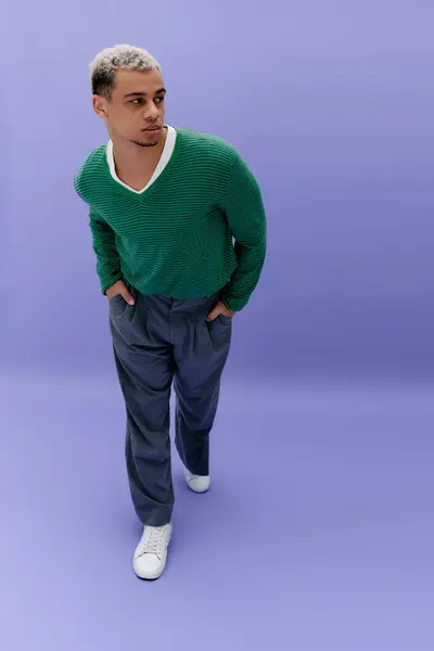 Un jeune homme afro-américain à la mode aux cheveux teints pose en toute confiance, mettant en valeur sa tenue. — Photo de stock