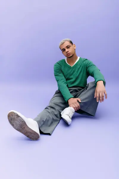 Confident young man with dyed hair flaunts his stylish outfit on a playful purple backdrop. — Stock Photo