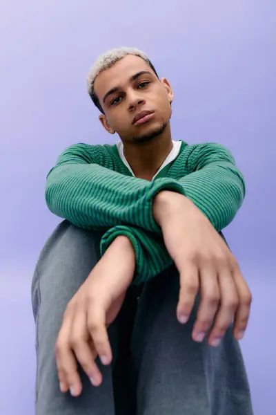 Un jeune homme aux cheveux teints pose en toute confiance dans une tenue vibrante et élégante. — Photo de stock