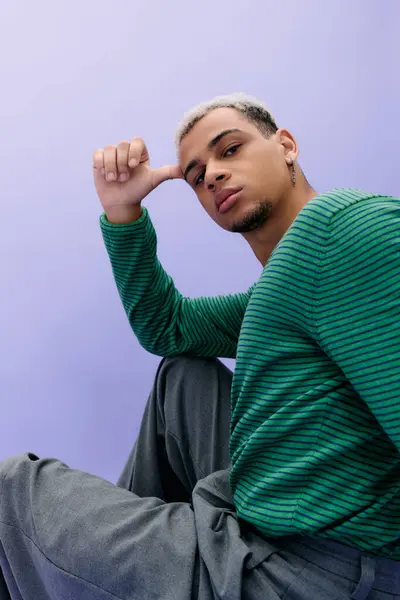 Un jeune homme afro-américain aux cheveux teints pose en toute confiance dans une tenue tendance, exprimant le style. — Photo de stock