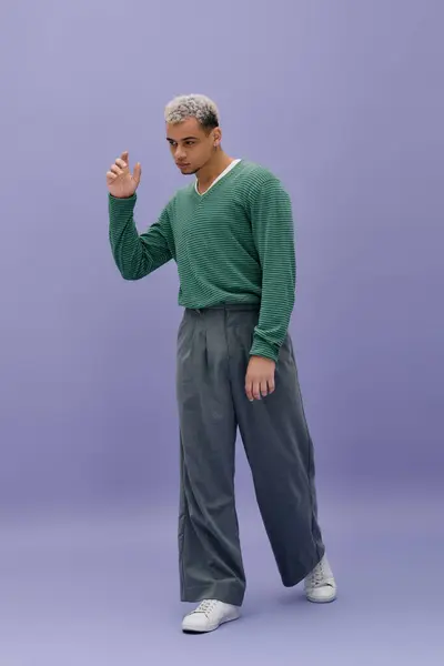 A stylish young Black man poses against a purple backdrop, showcasing his unique flair. — Stock Photo