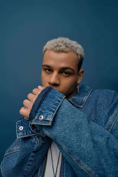 Un giovane uomo afroamericano mette in mostra il suo senso della moda in una giacca di jeans alla moda con i capelli tinti. — Foto stock