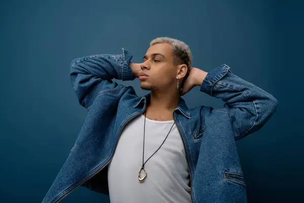 A young African American man with dyed hair poses confidently in a denim jacket, smiling. — Stock Photo