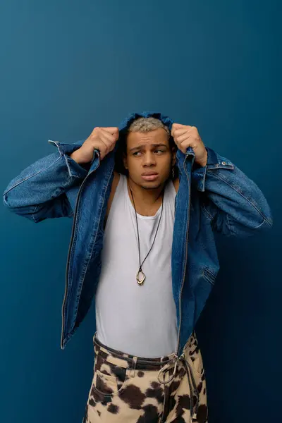 Un joven afroamericano muestra su estilo único con el pelo teñido, vestido con denim. - foto de stock