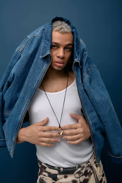 Un jeune homme afro-américain aux cheveux teints pose en toute confiance dans une veste en denim pour un look saisissant. — Photo de stock