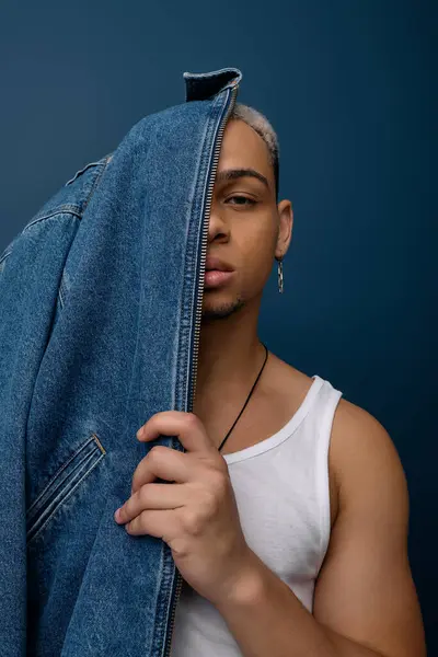 Un joven negro muestra su estilo en una chaqueta de mezclilla, destacando su individualidad. - foto de stock