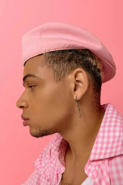 Un jeune homme afro-américain présente sa mode avec un béret élégant et une chemise à carreaux. — Photo de stock