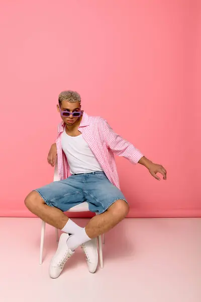 Un giovane afroamericano mette in mostra il suo senso della moda in camicia a scacchi e occhiali da sole. — Foto stock