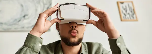 Handsome young man enjoys a moment of adventure using virtual reality in his cozy living area. — Stock Photo