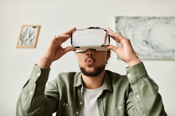 A handsome young man enjoys virtual reality adventures at home. — Stock Photo