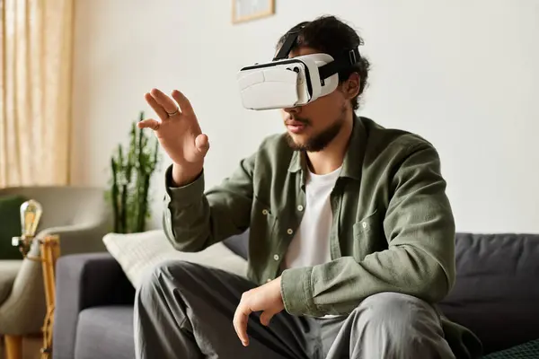 A young handsome man enjoys exploring virtual worlds while seated comfortably at home. — Stock Photo