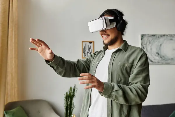 Handsome young man interacts with virtual reality in the comfort of his home. — Stock Photo