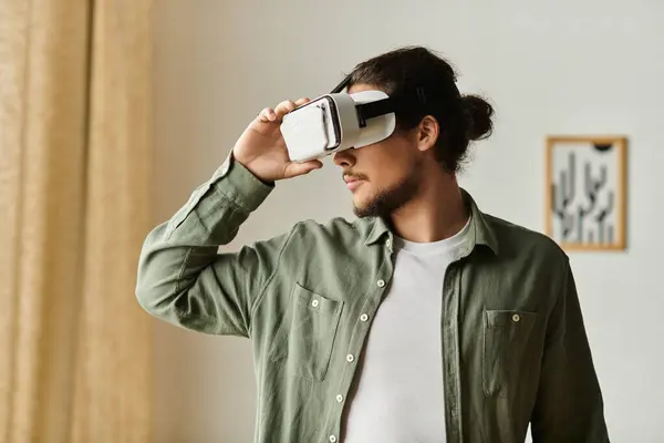 A young man joyfully enjoys virtual reality, fully immersed in a digital world at home. — Stock Photo