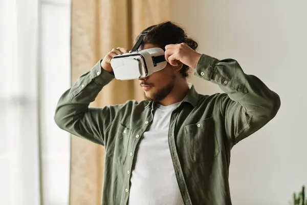 Engaged in immersive play, a young man explores new worlds in virtual reality within his cozy home. — Stock Photo