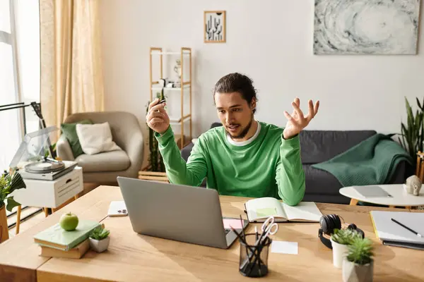 Young man in a green sweater passionately discussing ideas while working from home. — Stock Photo