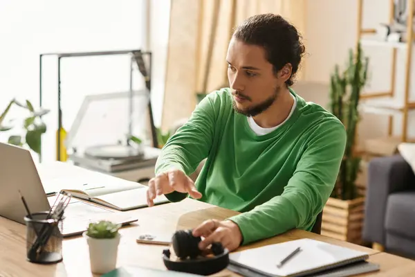 A young handsome man focuses on his tasks at home, surrounded by plants and personal items. — Stock Photo